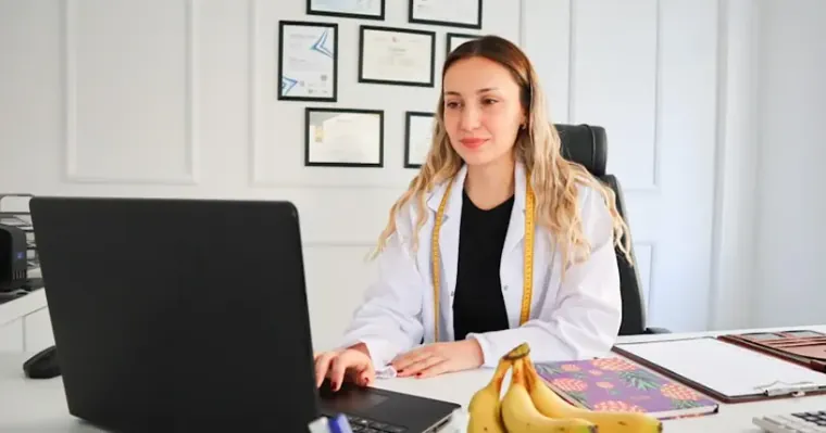 Doctor in a white coat working on a laptop